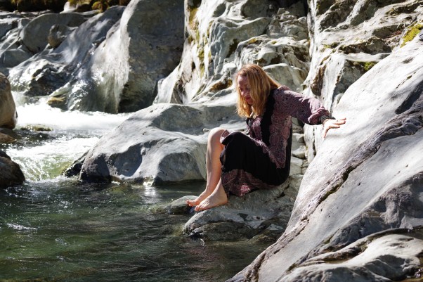 woman sitting next to the river