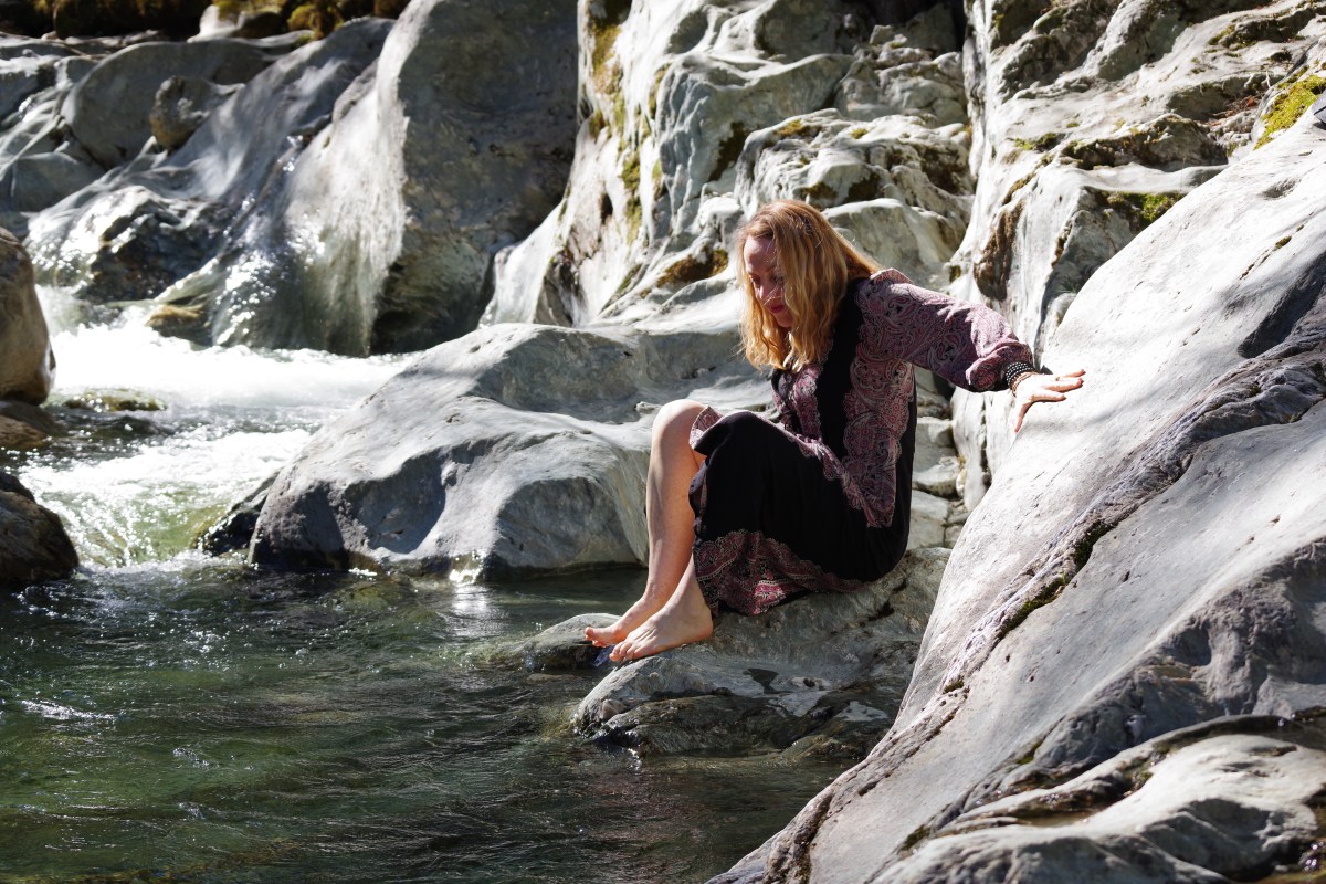 woman sitting next to the river