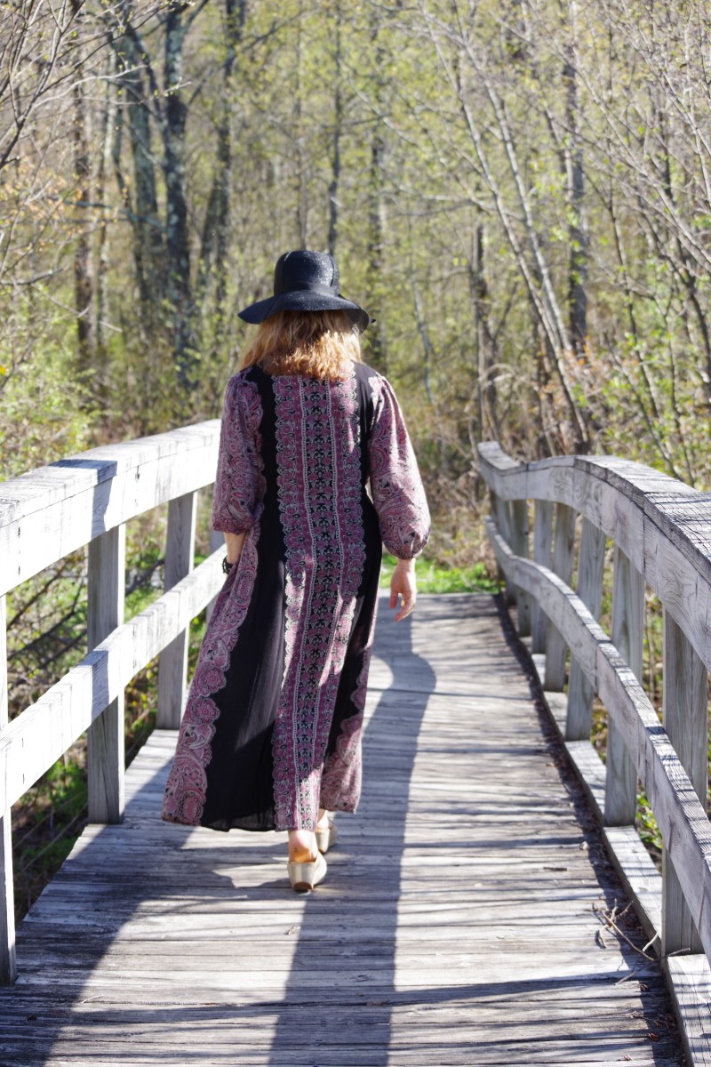 woman walking over a wooden bridge