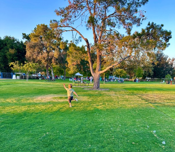 boy running across a park