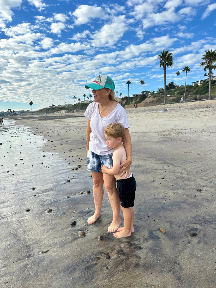 grandmother and grandson standing on the beach