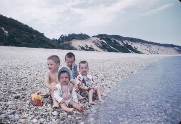 four little children on a rocky beach