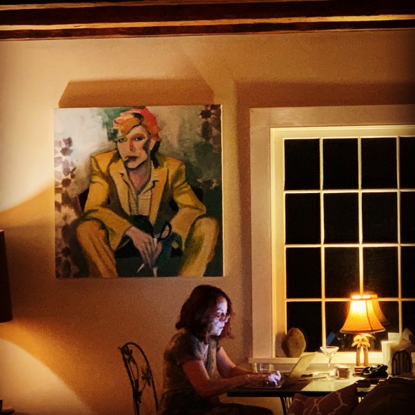 woman writing on her laptop in a dark living room